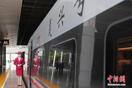 列车员在“复兴号”列车旁迎接旅客的到来。 <a target='_blank' href='http://www.chinanews.com/'>中新社</a>记者 殷立勤 摄