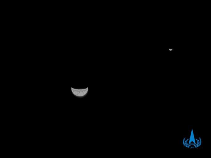 上图为2020年7月27日，天问一号探测器在飞离地球约120万公里处，利用光学导航敏感器拍摄的黑白地月合影。图片中，大的新月状球体为地球，小的新月状球体为月球。中国国家航天局供图