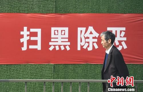 资料图：一位市民从“扫黑除恶”标语前走过。<a target='_blank' href='http://www.chinanews.com/'>中新社</a>记者 王刚 摄
