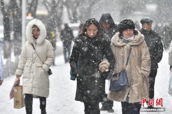 2月1日，新疆乌鲁木齐市迎来降雪天气。图为民众在纷纷扬扬的雪中出行。<a target='_blank' href='http://www.chinanews.com/'>中新社</a>记者 刘新 摄