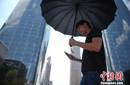 资料图：男子低头使用手机 中新社记者 刘占昆 摄