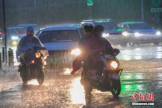 资料图：台风天气，民众冒雨出行。<a target=