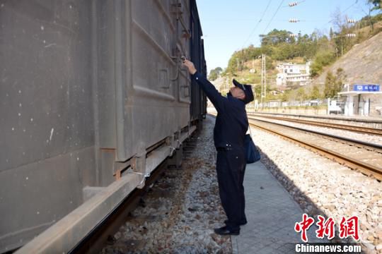 图为徐跃在对停留列车进行检查。　钟欣 摄