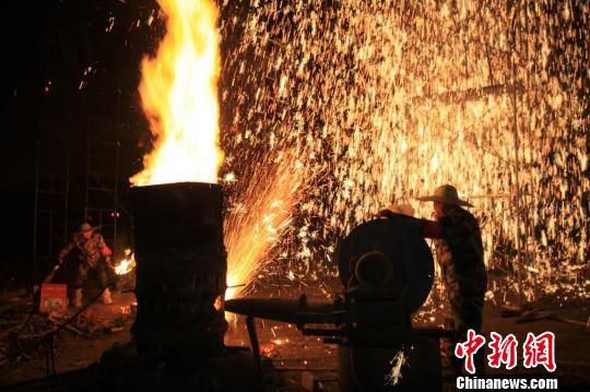 打铁花时，匠人们把砸碎的生铁装入锅中，拉起风箱将铁熔化成沸腾的铁汁，打花者从锅中用勺舀出铁水，倒在木板上，快速跑出数十步，将铁水向上抛起，在铁水还没有落地时用木板对准铁水猛击。受访者供图