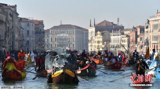 当地时间2月17日，意大利威尼斯狂欢节期间举行赛舟会，民众驾驶着独特装饰的船只行驶在运河上。
