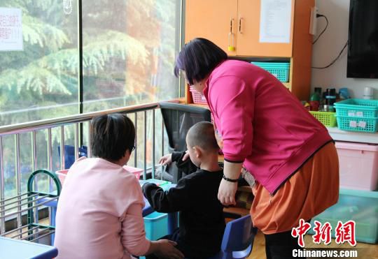走进济南安安特殊儿童康复中心，老师和家长正带着自闭症孩子玩游戏。　赵晓 摄