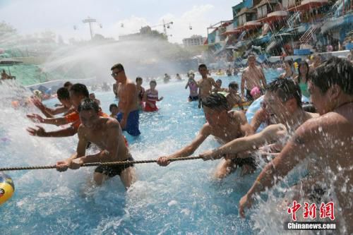 资料图：去年8月6日，重庆市气象台发布“高温橙色预警信号”，局地达40℃。图为一水上乐园举行水中拔河比赛。 杨孝勇 摄