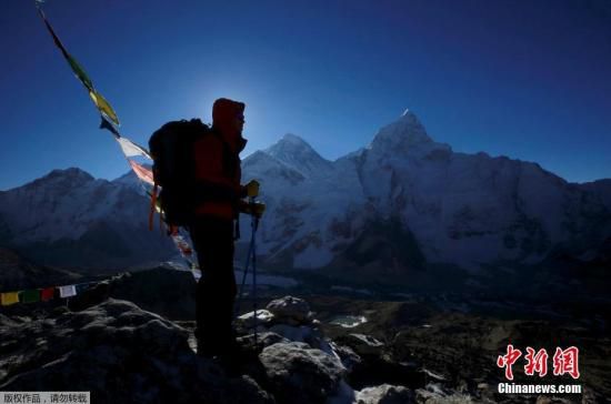 据悉，自1922年首批登山者在珠穆朗玛峰上罹难以来，已经有200多名登山者在这里不幸身亡。资料图为一名登山者站在珠峰前。