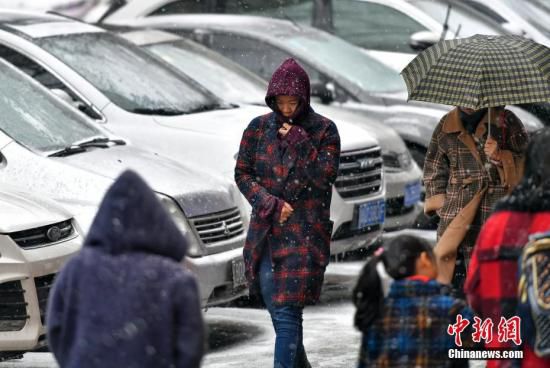 11月12日，持续浓雾天气的新疆乌鲁木齐市，又迎来一场雨雪天气，气温随之骤降。据新疆气象台预报，13日到15日，新疆大部分地区将出现降温和雨雪天气，相比于降水，降温更加明显。届时，北疆大部降温达8至10摄氏度，南疆地区普遍降温5至8摄氏度。图为风雪中，民众裹紧衣领脚步匆匆。<a target='_blank' href='http://www.chinanews.com/'>中新社</a>记者 刘新 摄
