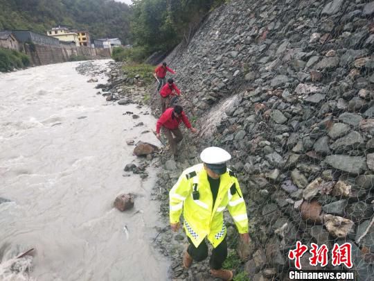 图为救援人员沿河道搜救。