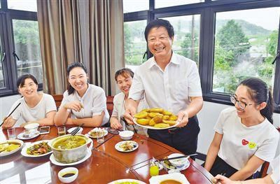 正在上菜的黄彭勋(右二)热情地向客人介绍农家乐传统手工特色菜——油盐麦果。陈斌荣摄