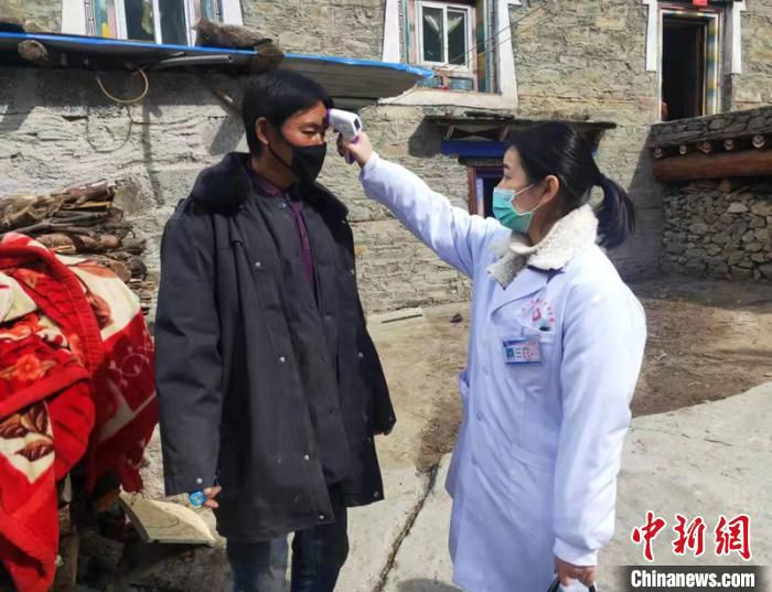 医护人员深入藏族村民家中为其测量体温。　甘孜轩 摄