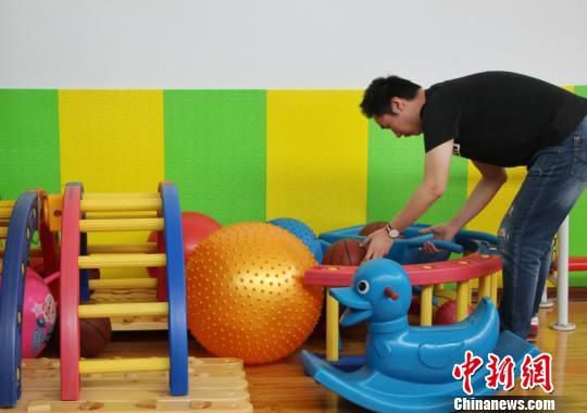 图为自闭症康复教师正在收拾整理自闭症孩子日常锻炼所使用的器具。　赵晓 摄