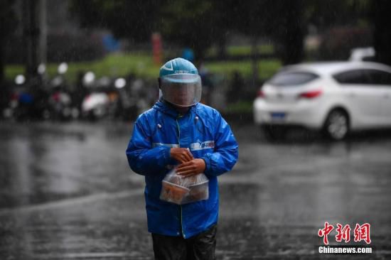 外卖小哥冒雨送餐。中新社记者 刘冉阳 摄