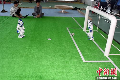 资料图：3月29日，厦门大学大学生创新创业实践基地，大学生团队演示他们研发出的机器人足球。 <a target=