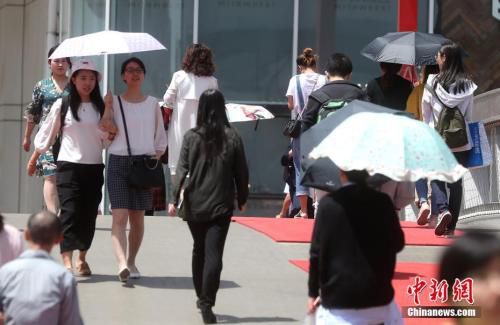 5月23日，北京西单街头，出行的民众撑伞防晒。 <a target='_blank' href='http://www.chinanews.com/'>中新社</a>记者 张宇 摄