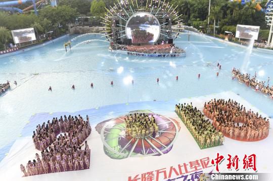 广州长隆水上乐园22日举办第十一届“万人比基尼”活动，数以千计的比基尼美女们齐聚在世界上最大的造浪池，摆出巨大的“2018”字样与旋转滑道造型，配以电音秀加持，现场气氛热辣火爆。　陈骥旻 摄