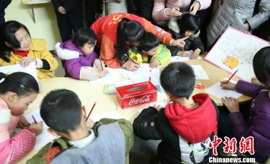 工作人员辅导“001号青青e家”的孩子画画。　张倩 摄